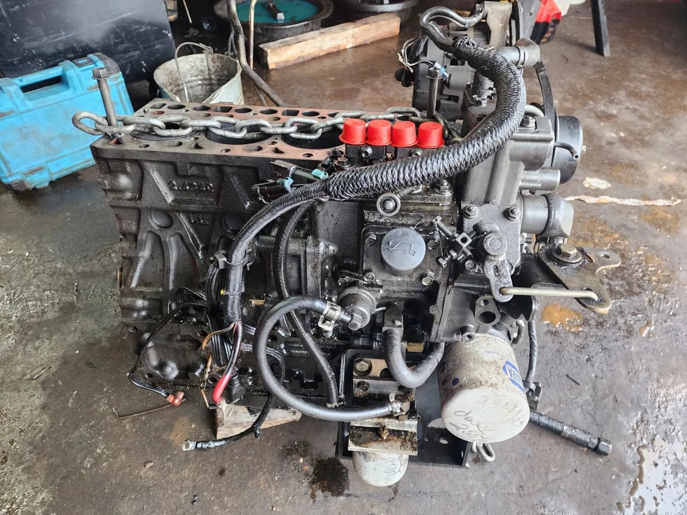 Kubota V2403 diesel engine from a Bobcat T180 on the shop floor with the cylinder head removed